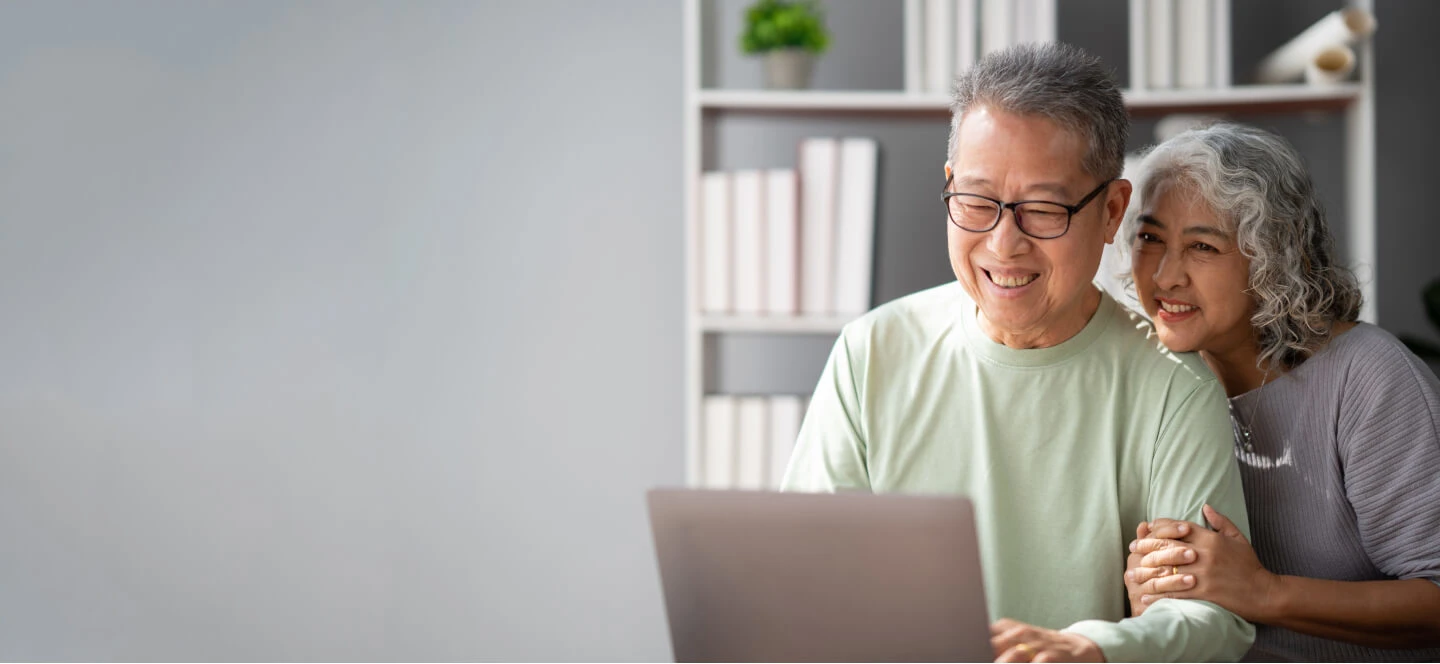 Elderly Asian Couple Looking At A Computer